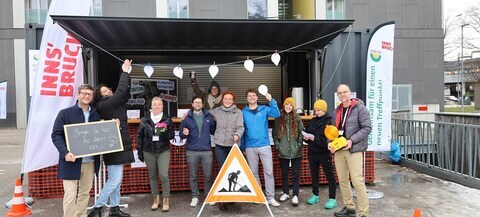 9 Personen vor einem Stand auf dem DDr.-Alois-Lugger-Platz