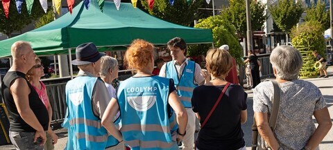 Personen mit Warnwesten bei Stadtteilfest, die den Plan präsentieren