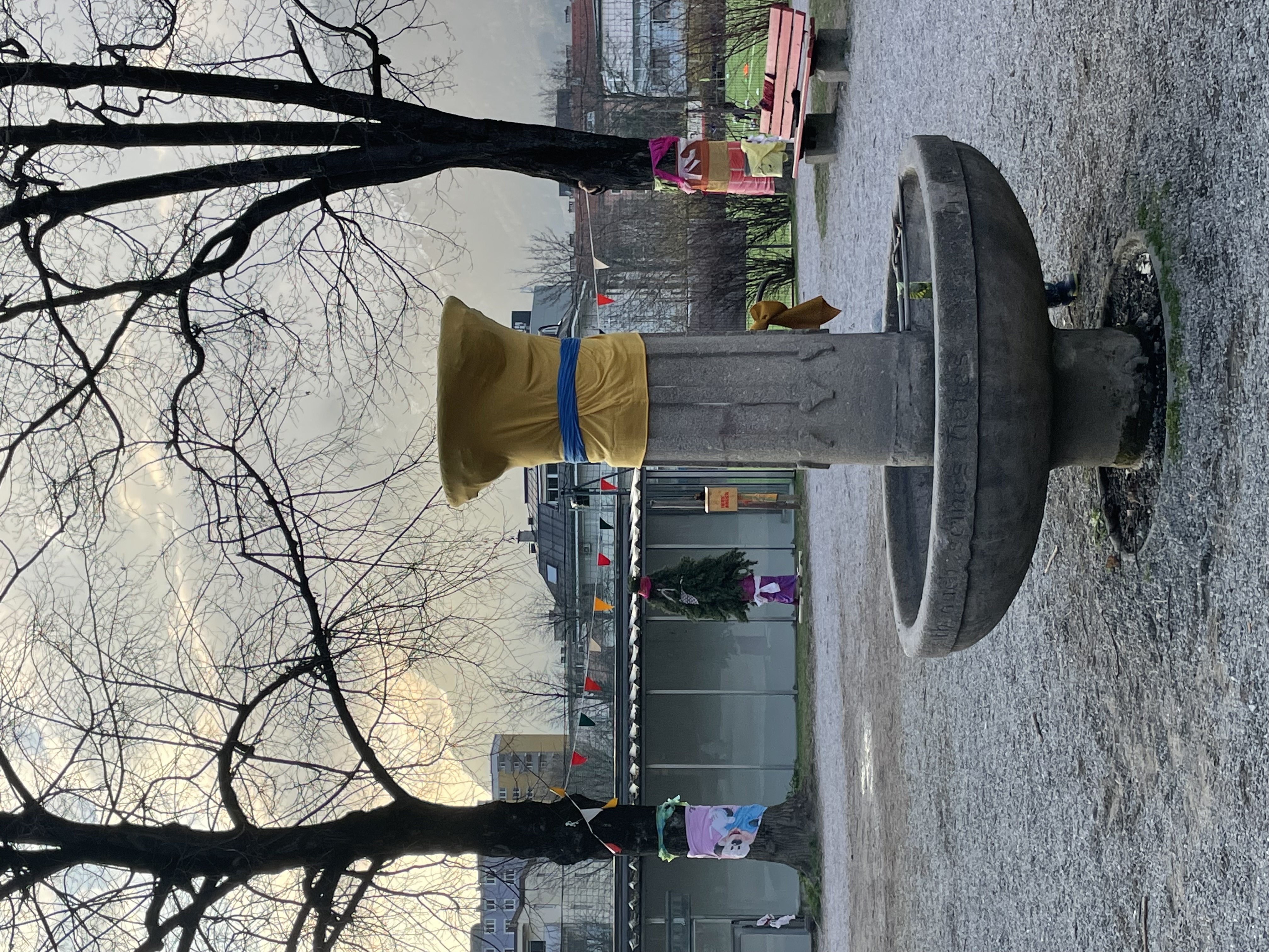 Brunnen und Bäume mit bunten Stoffen eingewickelt